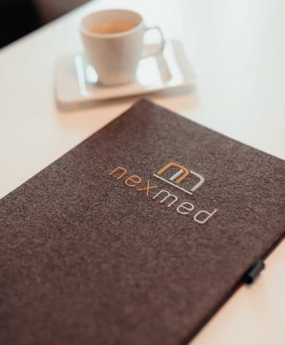 Mit dem nexmed-Logo verzierte Lodenmappe für sämtliche Unterlagen